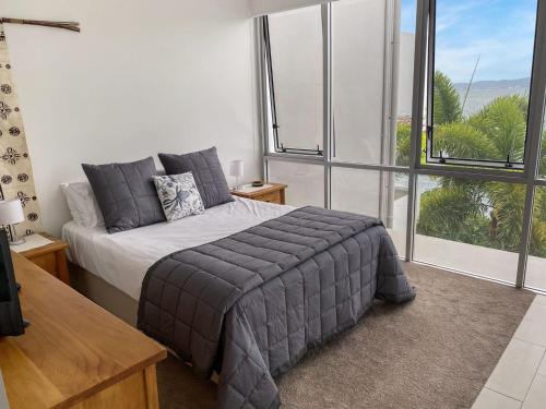 a bedroom with a bed and a large window at 1 Bright Point Apartment 2303 in Nelly Bay