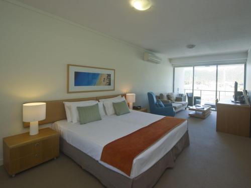 a bedroom with a large bed and a living room at Blue on Blue Studio Room 1242 in Nelly Bay