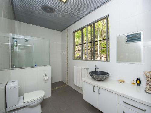La salle de bains est pourvue d'un lavabo, de toilettes et d'une fenêtre. dans l'établissement Horseshoe Bay Vista, à Horseshoe Bay