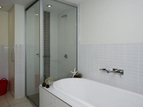 W łazience znajduje się wanna i przeszklony prysznic. w obiekcie Blue on Blue Superior Studio Room 1271 w mieście Nelly Bay