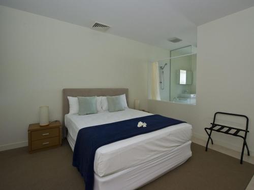 una camera con un grande letto e una sedia di 1 Bright Point Apartment 1402 a Nelly Bay