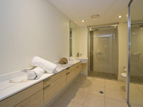 a bathroom with a shower and a toilet and a sink at Blue on Blue Apartment 812 in Nelly Bay