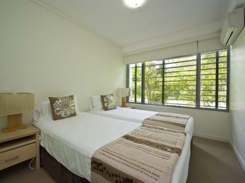 a bedroom with two beds and a window at Blue on Blue Apartment 812 in Nelly Bay