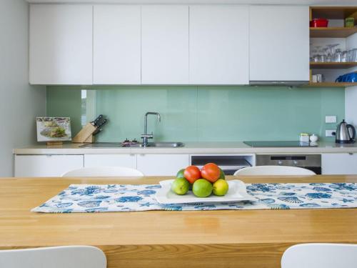 a table with a plate of fruit on it in a kitchen at 1 Bright Point Apartment 5102 in Nelly Bay