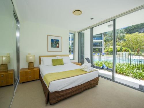 a bedroom with a bed and a large window at Blue on Blue Apartment 1011 in Nelly Bay