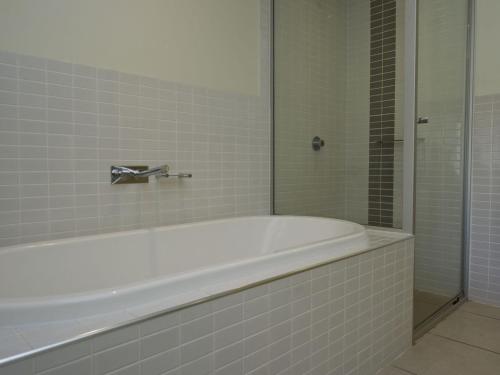 uma banheira branca na casa de banho com um chuveiro em Blue on Blue Superior Studio Room 1241 em Nelly Bay