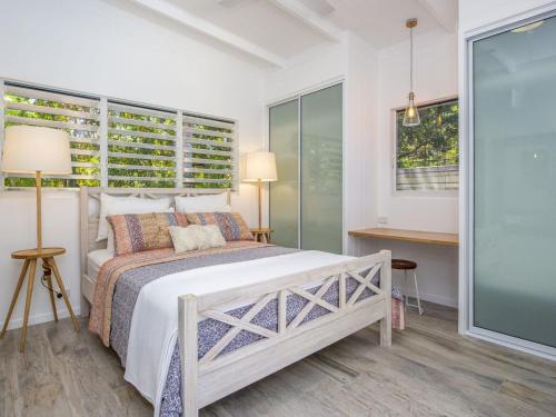 a white bedroom with a bed and a window at Papillon Bleu in Horseshoe Bay