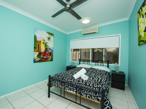 a bedroom with a bed and a blue wall at Azure on Geoffrey Bay in Arcadia