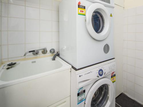 a washing machine and a sink in a bathroom at Azure on Geoffrey Bay in Arcadia