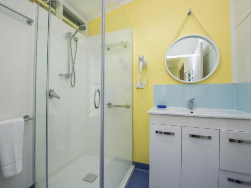 a bathroom with a shower and a sink and a mirror at Kooyong Apartment 2 in Arcadia