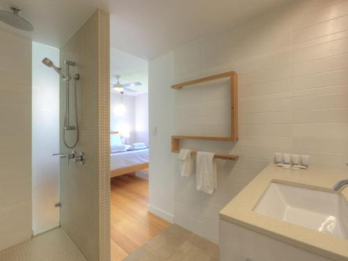 a white bathroom with a sink and a shower at Maggies Beachfront Apartment 8 in Horseshoe Bay