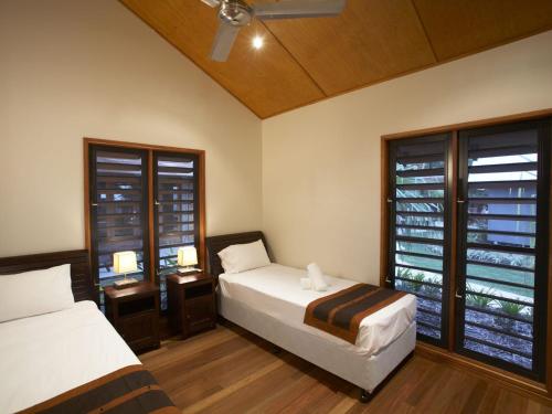 Un dormitorio con dos camas y una ventana. en Pure Magnetic Villa 1, en Nelly Bay