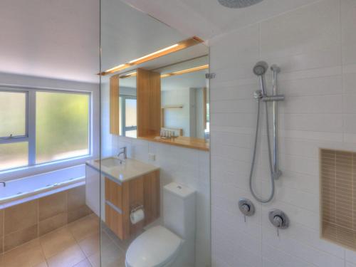 y baño con aseo, lavabo y ducha. en Maggies Beachfront Apartment 10 en Horseshoe Bay