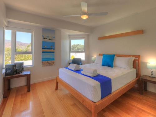 a bedroom with a large bed and two windows at Maggies Beachfront Apartment 6 in Horseshoe Bay