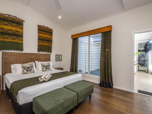 a bedroom with a large bed and a large window at Reflections Emerald Villa 1 in Picnic Bay