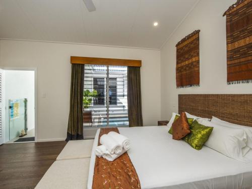 Reflections Amber Villa 3 في Picnic Bay: غرفة نوم بسرير ابيض كبير ونافذة