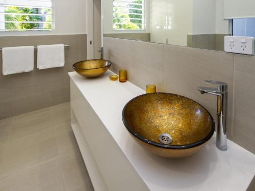 La salle de bains est pourvue d'un grand lavabo sur un comptoir. dans l'établissement Reflections Amber Villa 3, à Picnic Bay
