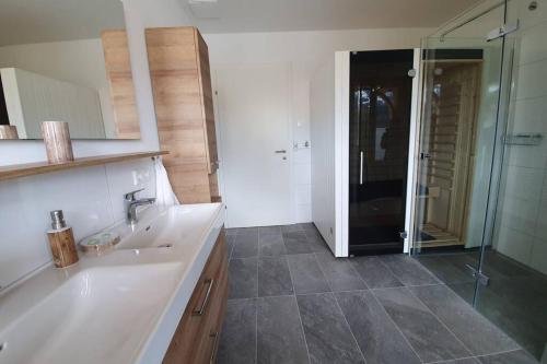 łazienka z białą umywalką i prysznicem w obiekcie Galerie Wohnung Hechelstein / Top 106 w mieście Tauplitz