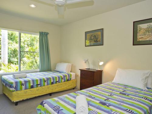 a bedroom with two beds and a window at Johns Tropical Island Home in Nelly Bay