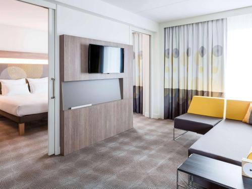 a hotel room with a bed and a television at Novotel Amsterdam Schiphol Airport in Hoofddorp