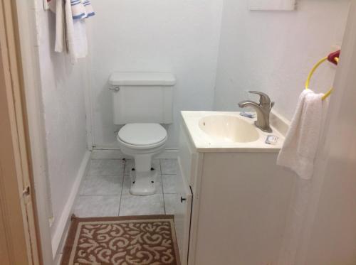 a small bathroom with a toilet and a sink at Lucky 7/ Rainbow motel in Murphy