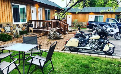 a motorcycle parked in a yard with a table and chairs at Evergreen Motel in Libby