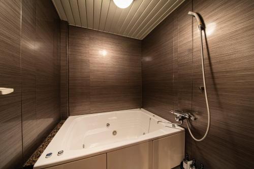 a bathroom with a bath tub and a shower at リトル チャペル ココナッツ 天王寺 in Osaka