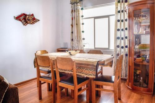 een eetkamer met een tafel en stoelen en een raam bij Piso de Kireyna in Cuzco