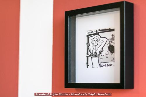 a framed drawing of a woman in a bathroom stall at 4 Star Bologna Train Station - Self Check-In in Bologna