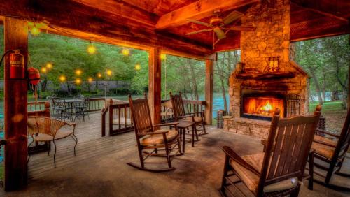 a screened in porch with chairs and a fireplace at Hooked On Toccoa in Blue Ridge