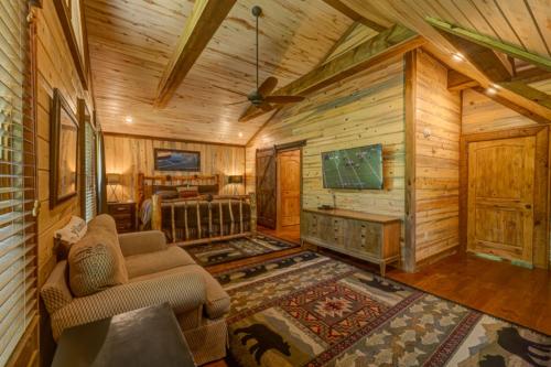 a living room in a log cabin with a tv at Hooked On Toccoa in Blue Ridge