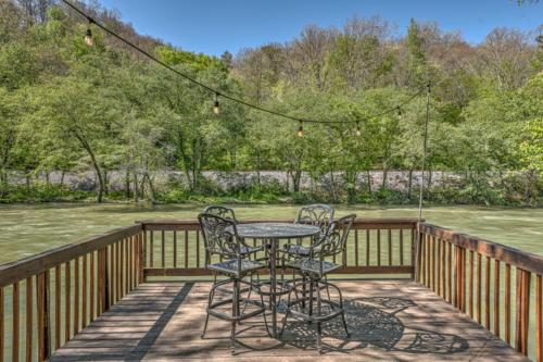 a patio with a table and chairs on a deck at Hooked On Toccoa in Blue Ridge