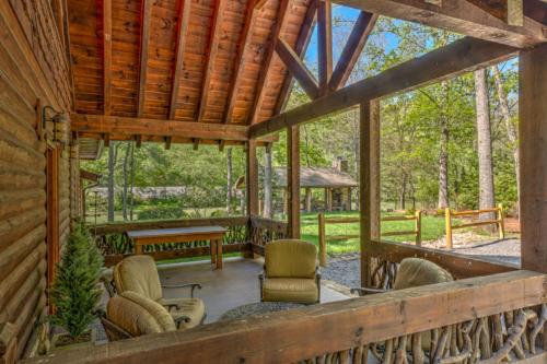 a porch of a cabin with chairs and a table at Hooked On Toccoa in Blue Ridge