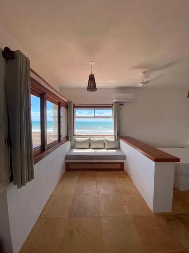 een kamer met een bank en een raam met uitzicht op het strand bij Navegantes Poente in Guajiru