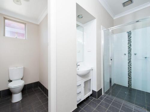 a bathroom with a toilet and a sink and a shower at Magnolias in Fingal Bay