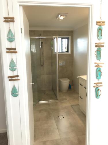 a bathroom with a shower with a glass door at 2BD Family or Couple Guesthouse Upstairs near Turf club, HOTA in Bundall in Gold Coast