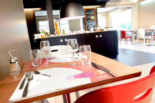 a restaurant with a table with wine glasses on it at Campanile Lens in Lens