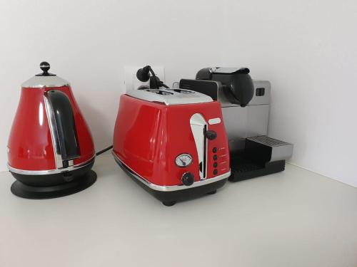 a red and white toasters sitting on a counter at Peaceful Mount Studio Moments to Beach & Downtown in Mount Maunganui