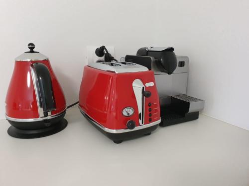 a red and white toasters sitting on a counter at Cosy Mount Studio Moments to Beach & Downtown in Mount Maunganui