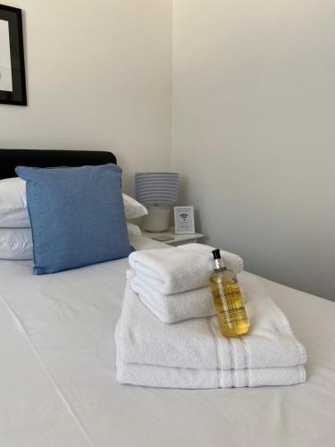 a room with a bed with towels and a bottle on it at Tirah Guest House in Aldeburgh