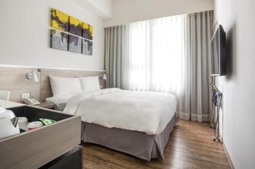 a hotel room with a bed and a television at CityInn Hotel Plus- Fuxing North Road Branch in Taipei