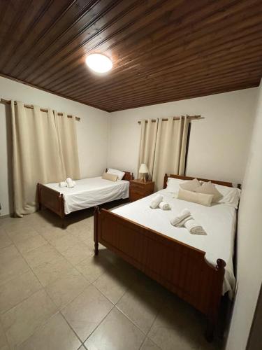 a bedroom with two beds and a wooden ceiling at Pramateftis House in Agros