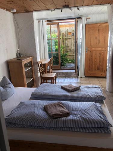 two beds sitting in a room with a window at Schatzl Hütte in Bad Tölz