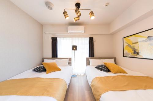 福岡市にあるSG RESIDENCE INN HAKATAの窓のある部屋にツインベッドが2台
