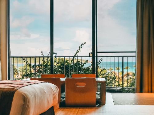 a room with a bed and a large window with the ocean at Miyakojima Tokyu Hotel & Resorts in Miyako-jima
