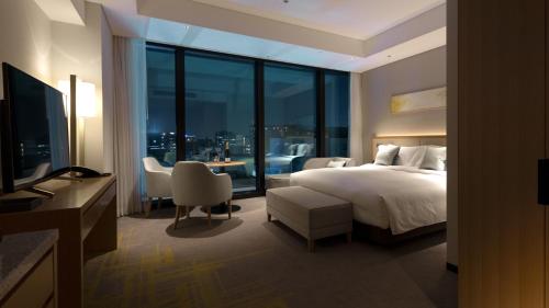 a hotel room with a bed and a table and chairs at Miyako Hotel Hakata in Fukuoka