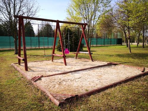 a swing set in a park in the grass at Laguna Panzió in Gárdony