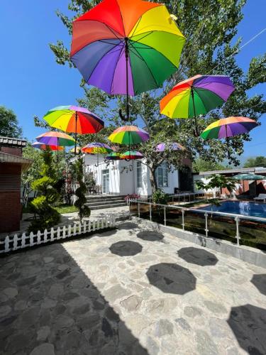 a group of colorful umbrellas hanging over a patio at Qafqaz Fountain Villa in Gabala