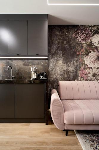 a living room with a pink couch and a wallpaper at Jacuzzi Apartment Main Square in Kraków