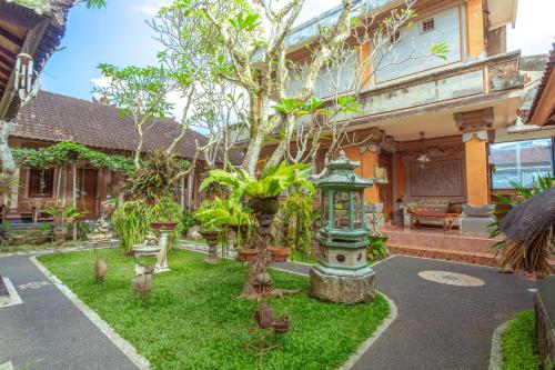 a garden in front of a house with a tree at Teba House Ubud by ecommerceloka - CHSE Certified in Ubud